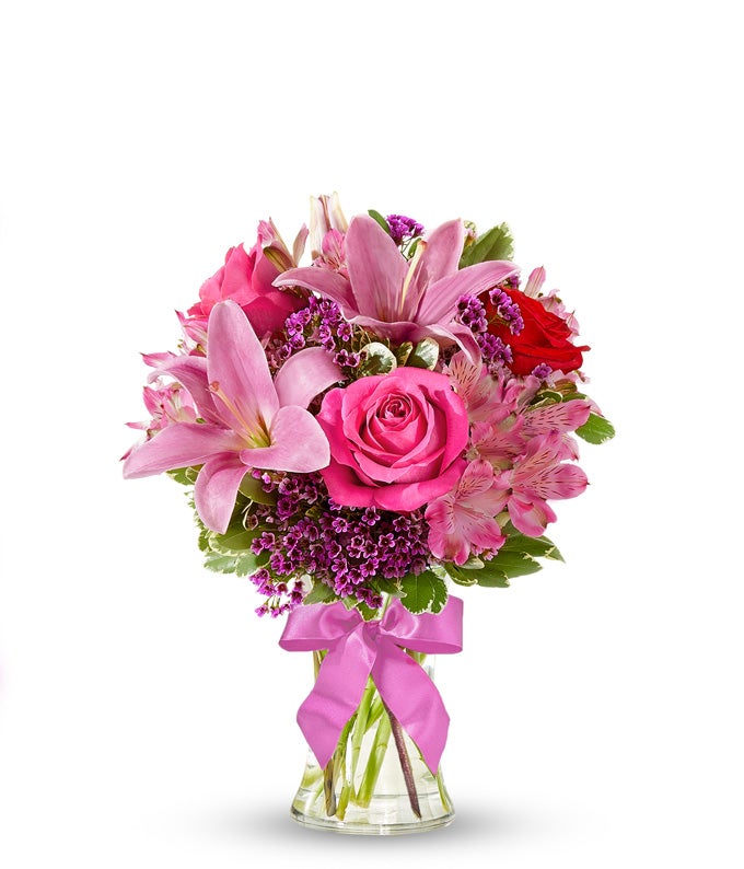 Red roses, pink lilies and pink alstroemeria and glass vase